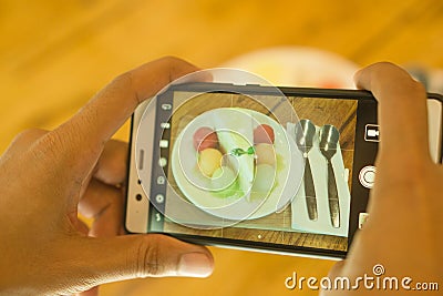 Use a smartphone Take a picture of a fruit cake on a coffee shop background. Stock Photo
