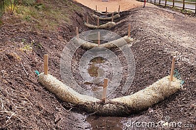 The use of straw wattles. Land drainage works Stock Photo
