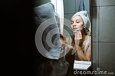 Use Wash Off Face Mask, Using Peel-Off Mask Correctly. Young woman in towel on her head wash face after removing mask in Stock Photo