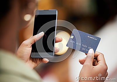 Use your phone to simplify your life. a young woman using her smartphone to make card payments. Stock Photo