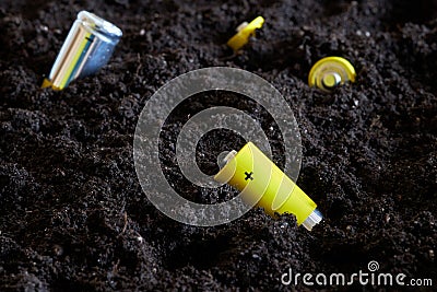 Used batteries in the ground. Hazardous waste that pollutes the environment. Environmental protection Stock Photo