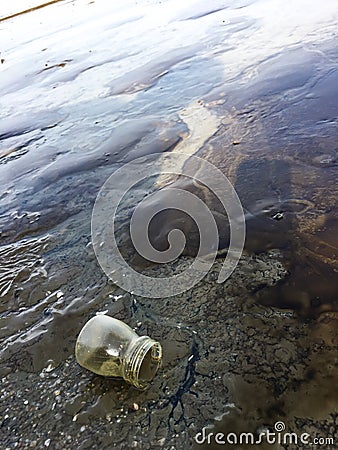 Used glass bottle on the beach, Beach pollution concept Stock Photo