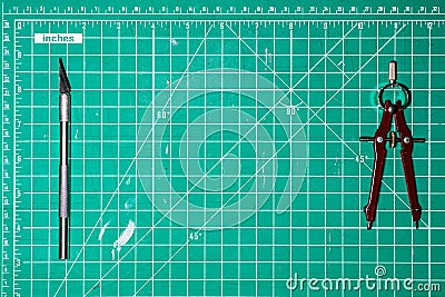 Used Green cutting mat with a compass and a razor knife with copy room Stock Photo