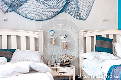 Used linens. Bedsheet and pillows. Messed up bedsheet and linens. Fishing net hanging by the wall Stock Photo