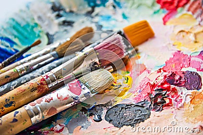 Used paint brushes on a colorful palette Stock Photo