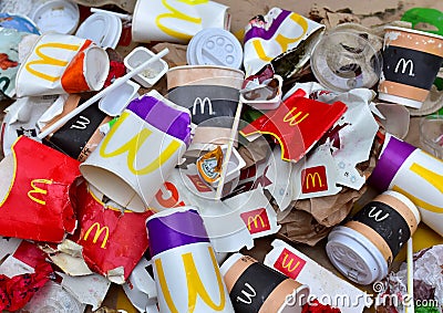 Used paper disposable packs McDonalds. Fast foodâ€™s litter legacy. Discarded paper coffee cup. Pile of abandoned garbage Editorial Stock Photo