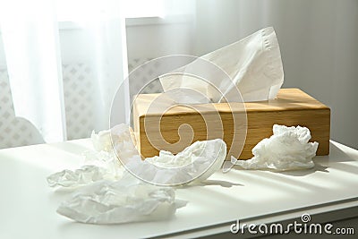 Used paper tissues and holder on table near window Stock Photo