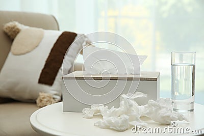 Used paper tissues, holder and water on table Stock Photo