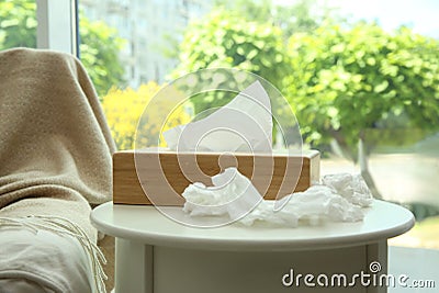 Used paper tissues and wooden holder on table Stock Photo