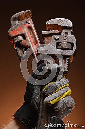 Pipe wrenches in hand of workman Stock Photo