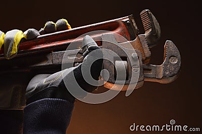 Pipe wrenches in hand of workman Stock Photo