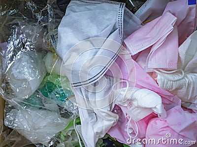 Used sanitary napkins, surgical face mask, and plastic in the trash. Infectious waste management concept. Waste separation. Stock Photo