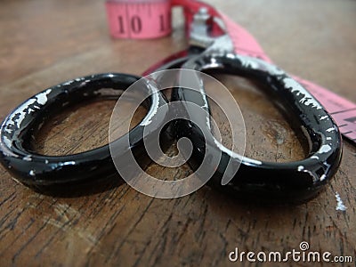 Used scissor on a work table with metric tape lateral closeup Stock Photo