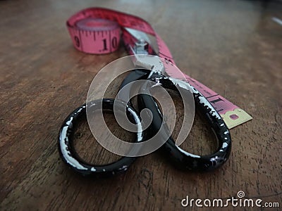 Used scissor on a work table with metric tape lateral closeup Stock Photo