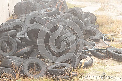 Used tires lie on the ground in a landfill in ukraine, an environmental problem of the industry Stock Photo