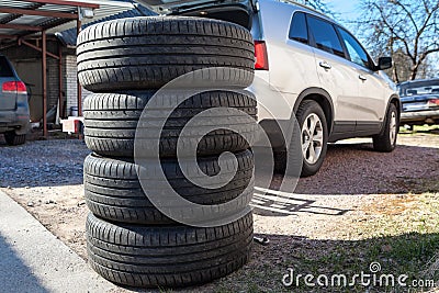 Used wheels with summer tires for suv car stacking on earth, seasonal tyre change Stock Photo