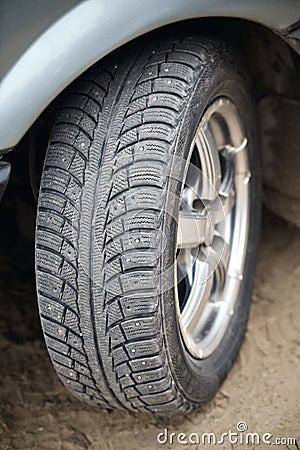 Used winter tire with metal studs closeup, some studs lost. Protector for winter studded tire. Lost spikes old rubber Stock Photo