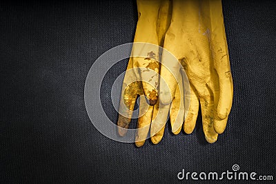 Used yellow rubber gloves on a black background Stock Photo