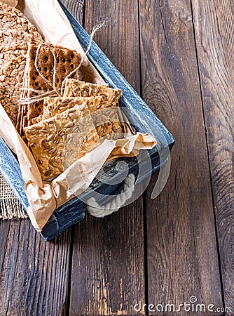 Useful dietary grain loaves rye, buckwheat, wheat in an old wooden box on a wooden background.vertical version Stock Photo