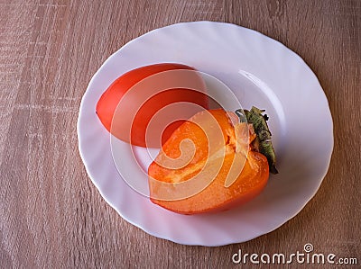 Persimmon fruit, close ripe fruits on a plate Stock Photo