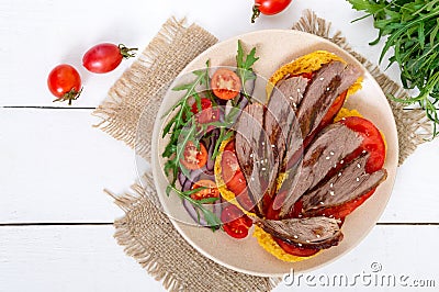 Useful sandwiches: goose breast on pumpkin bread, salad from tomatoes, arugula, red onions Stock Photo