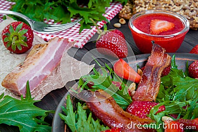 Useful strawberry salad with arugula, nuts and bacon, berry sauce Stock Photo