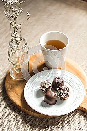 Useful sweets with coconut in chocolate and tea Stock Photo