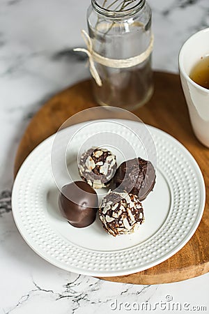 Useful sweets with coconut in chocolate and tea Stock Photo