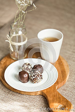 Useful sweets with coconut in chocolate and tea Stock Photo