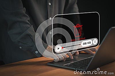 User using a laptop computer with a Video deleted message and a play icon overlay, representing content removal. Stock Photo