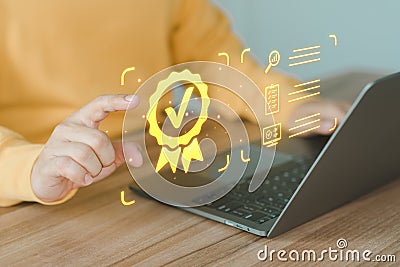 User using a laptop with virtual screen assessment sign of the top service quality assurance certificate. Stock Photo