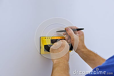 Uses Multi-Sense Technology to find studs more accurately through difficult surfaces. Man hand is scanning wall by Stock Photo