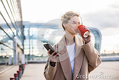 Usiness woman using phone near airport entrance Stock Photo