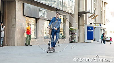 Using Electric Scooter on the street Editorial Stock Photo