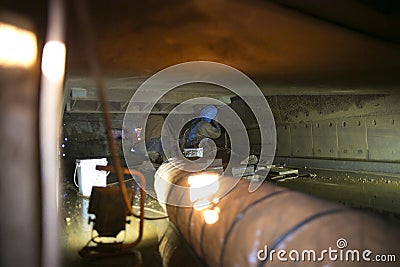 Using exhausting ventilation system fan safety precaution while rope access miners commencing oxy torch cutting metal hot work in Stock Photo