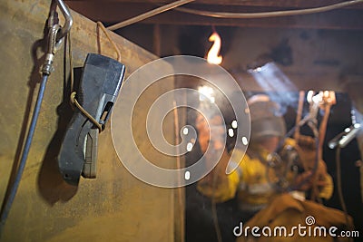 Using Gas detector while rope access welder commencing welding in confined space Stock Photo