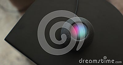 Using an HomePod Mini speaker - the smart speaker is reacting to voice listening to human commands and signalling its Stock Photo