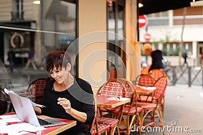 tired female employee of bank adds financial plan in laptop Stock Photo