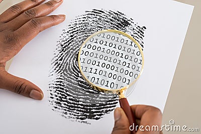 Using Magnifying Glass To Check Binary Code Within Finger Print Stock Photo