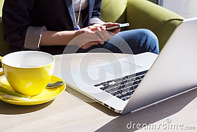 Using mobile phone and laptop computer in cafe Stock Photo