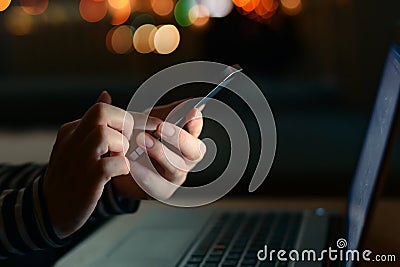 Using smartphone and laptop computer late at night Stock Photo