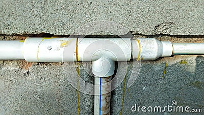 Using tee, reducer, coupling for Connection Of pvc pipe fittings For Water pipeline attaching with wall, plumber and plumbing c Stock Photo