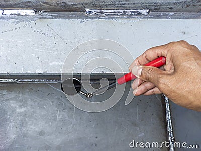 Using welding inspection mirror for check visual welding defects in a niche Stock Photo