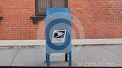 Blue USPS Mailbox in front of Brick Wall Editorial Stock Photo