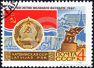 Post stamp printed in the USSR shows Coat of Arms, Flag and monument Latvian SSR, serie `50 years of the Great October`.Philately Editorial Stock Photo