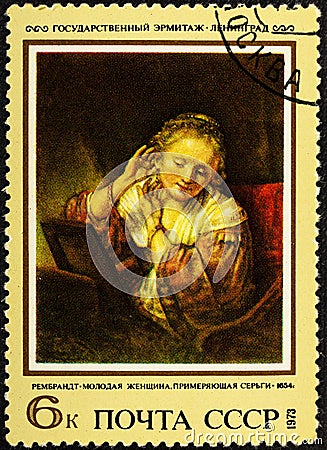 USSR - CIRCA 1973: A stamp printed in the USSR shows painting Young woman trying earrings by artist Rembrandt, stamp Editorial Stock Photo