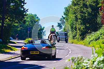 Horse riders and cars Battery Hill road East Sussex England Editorial Stock Photo