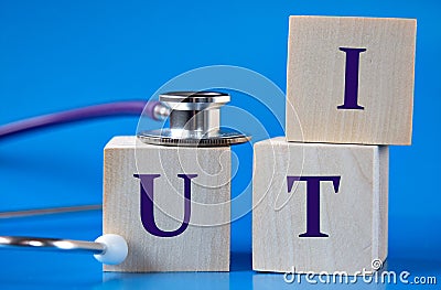 UTI - acronym on wooden large cubes on blue background with stethoscope Stock Photo