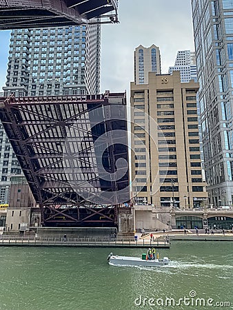Utility boat travels under a Chicago drawbridge as it opens Editorial Stock Photo
