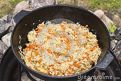 Uzbek national dish pilaf rice in a cast iron cauldron Stock Photo